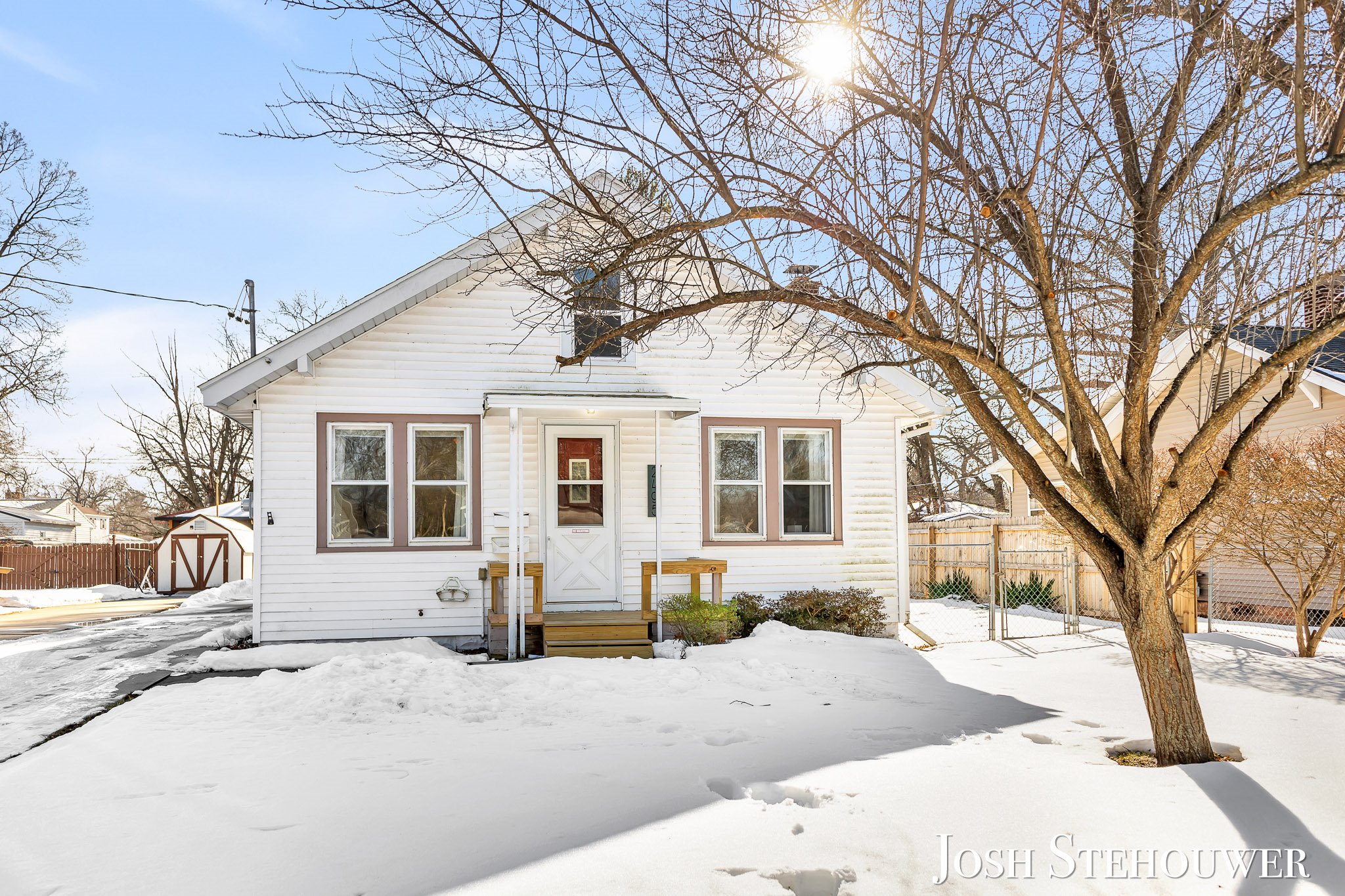 Grand Haven home exterior covered in winter snow with sunlight