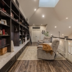 Library loft with shelves, soft lighting, and cozy seating in a Holland, MI home.