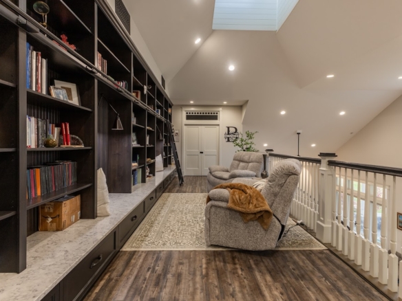 Library loft with shelves, soft lighting, and cozy seating in a Holland, MI home.
