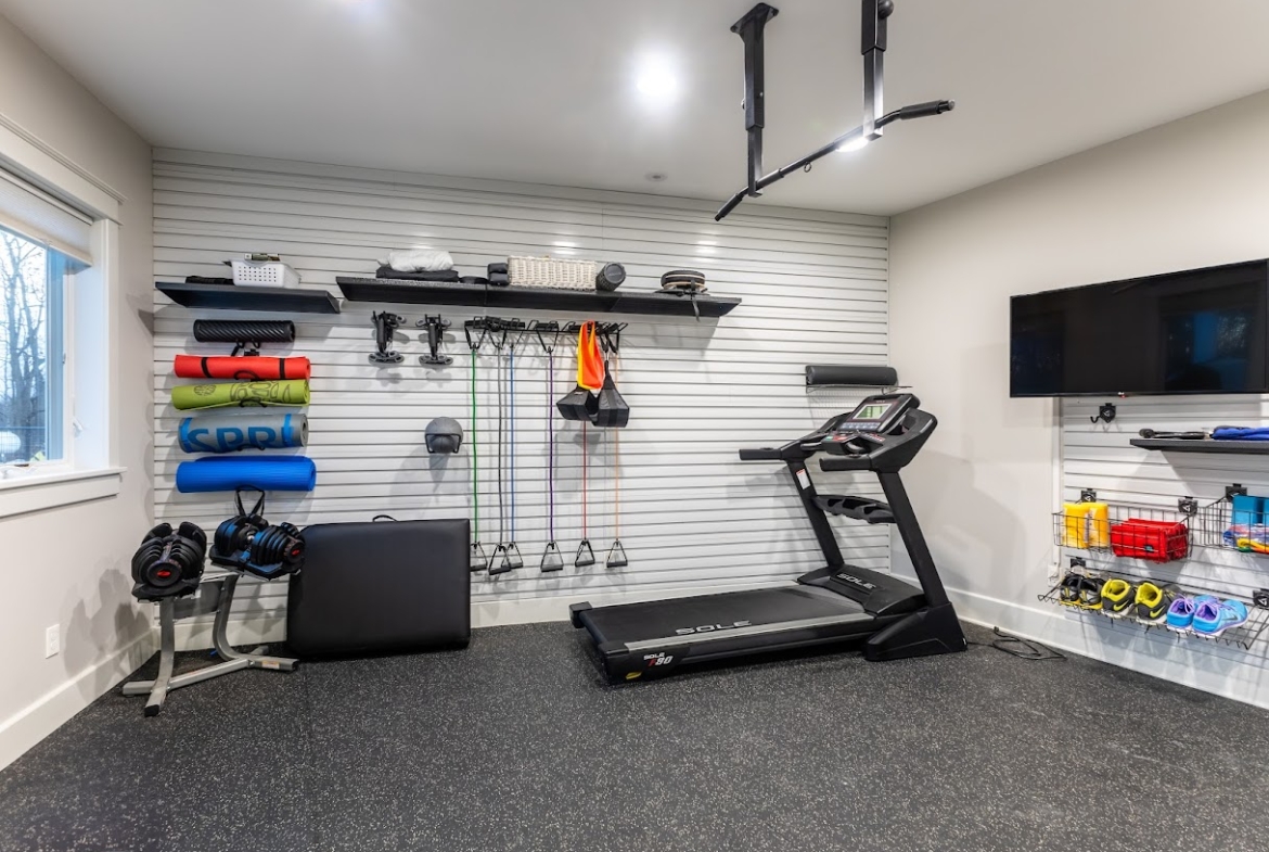 Home gym setup with treadmill and equipment in a West Michigan property.