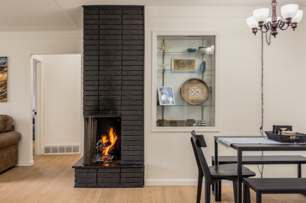 Modern Michigan dining area with black brick fireplace and cozy neutral decor