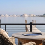 Lakeshore home deck with fire table, seating, and dock on a West Michigan waterway
