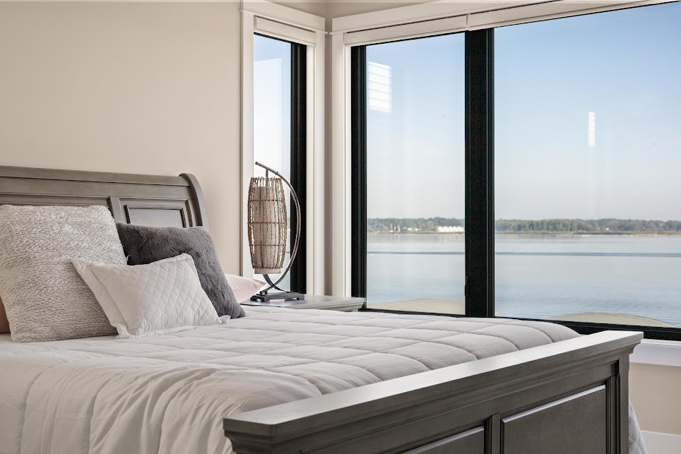 Bright guest bedroom with natural light and simple staging in Spring Lake lake view home
